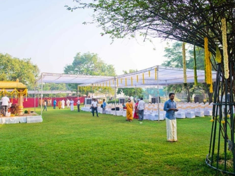 A charming outdoor wedding reception with neatly arranged tables, surrounded by nature's beauty.